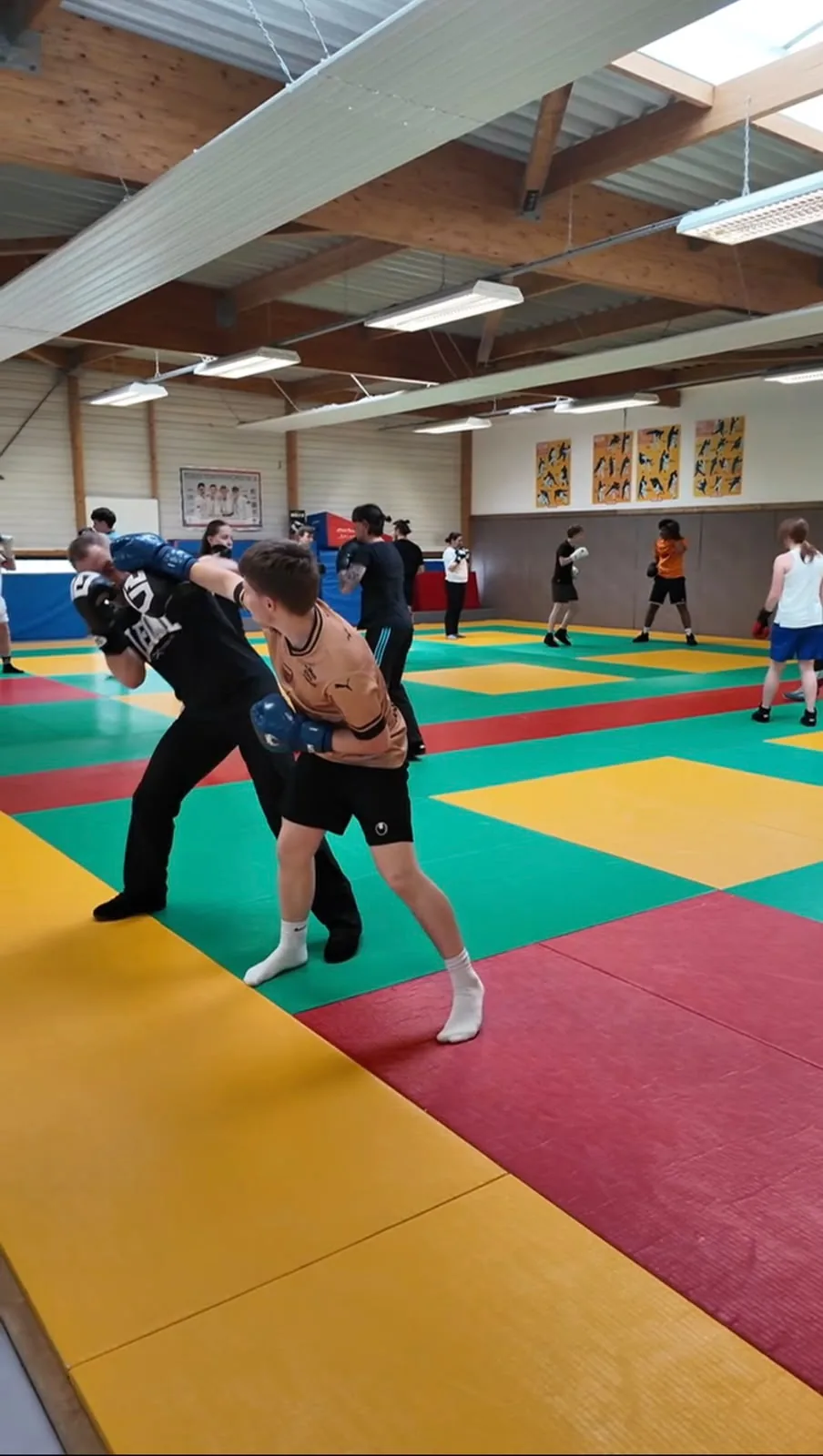 Un jeune boxeur porte un coup de poing face à un entraîneur.