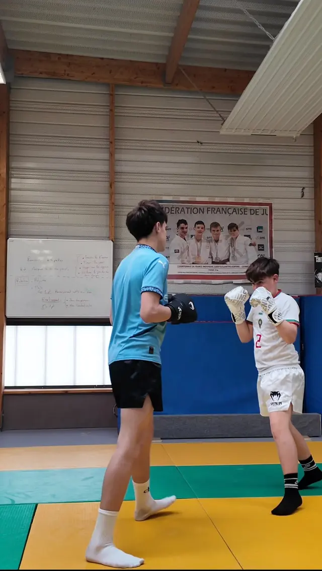 Deux jeunes boxeurs gantés, en garde.